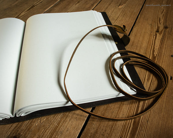 A4 brown and green leather journal with Neolithic triple spiral design open - earthworks journals
