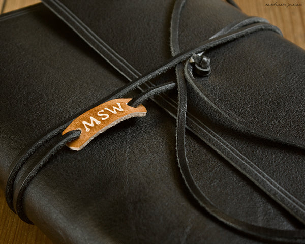Personalised leather tag on black leather wrap journal - earthworks journals